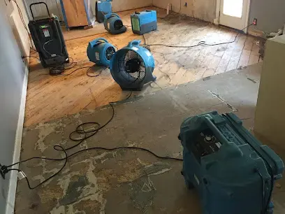 Flooring pulled up with air movers and a dehumidifier drying the floor after a leak underneath